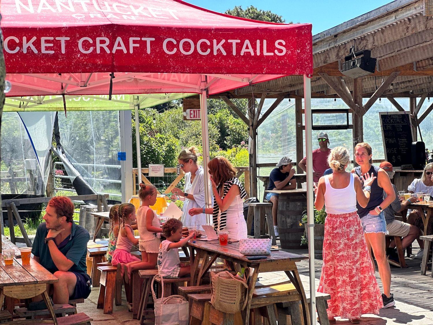 Group of people under red tent at Cisco Brewery.