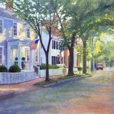 Watercolor of white houses and American flag on tree-lined street. 