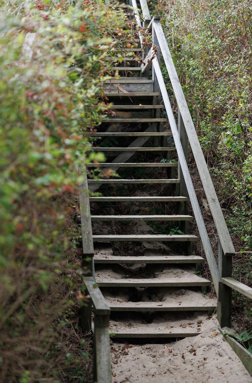 Wooden steps leading to a sandy beach.